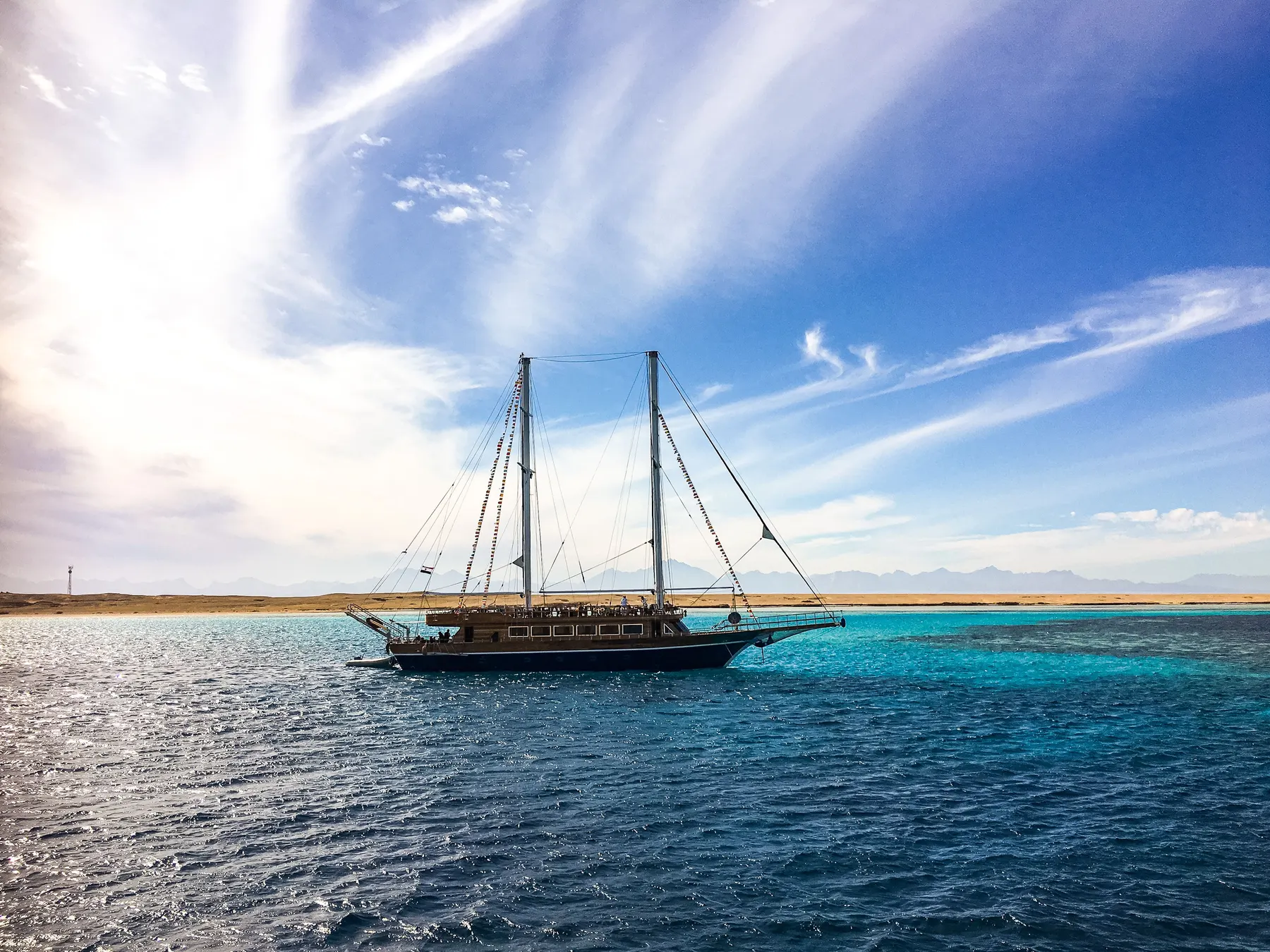 A two-masted boat anchored in clear blue water off Giftun island, Hurghada.