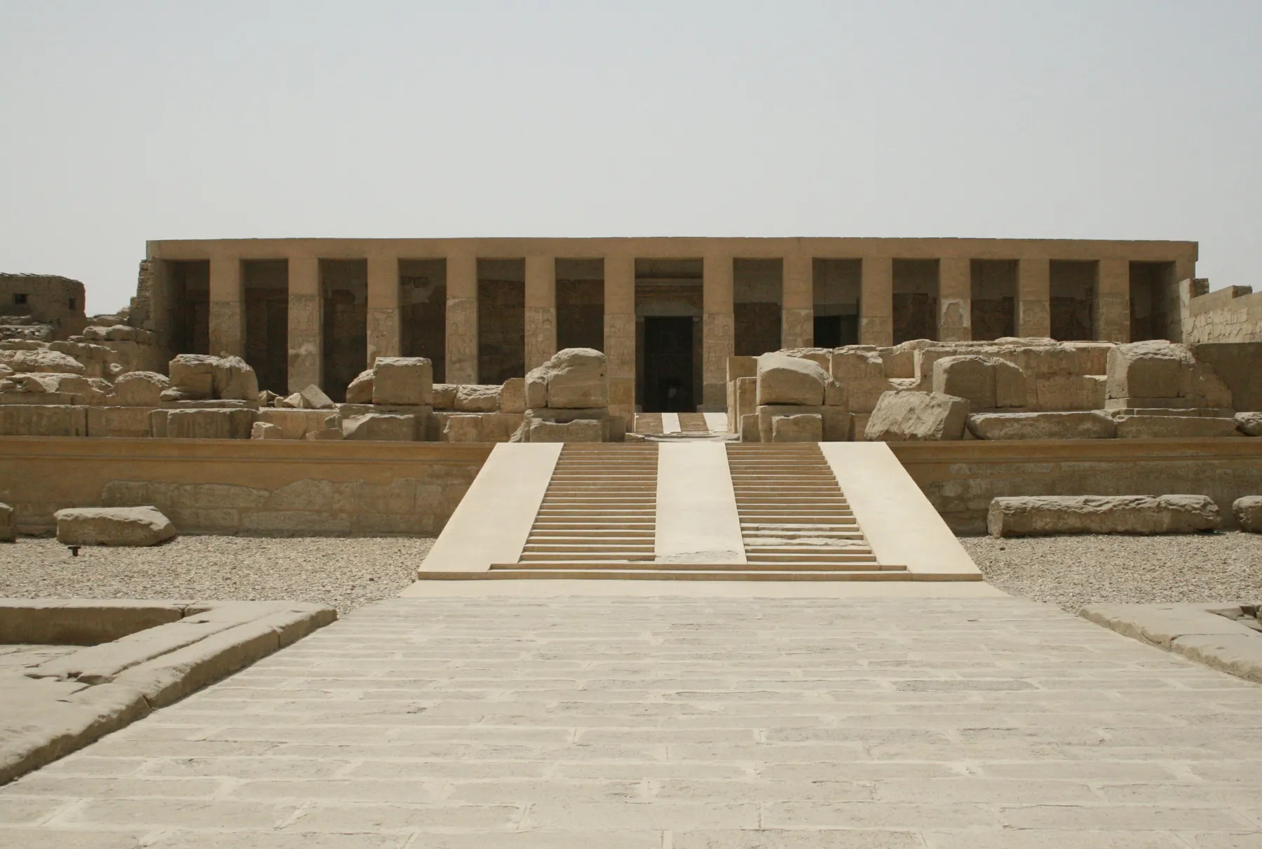 The pillared facade of the Temple of Seti I at Abydos, reached by a broad central ramp across its ruined courts.