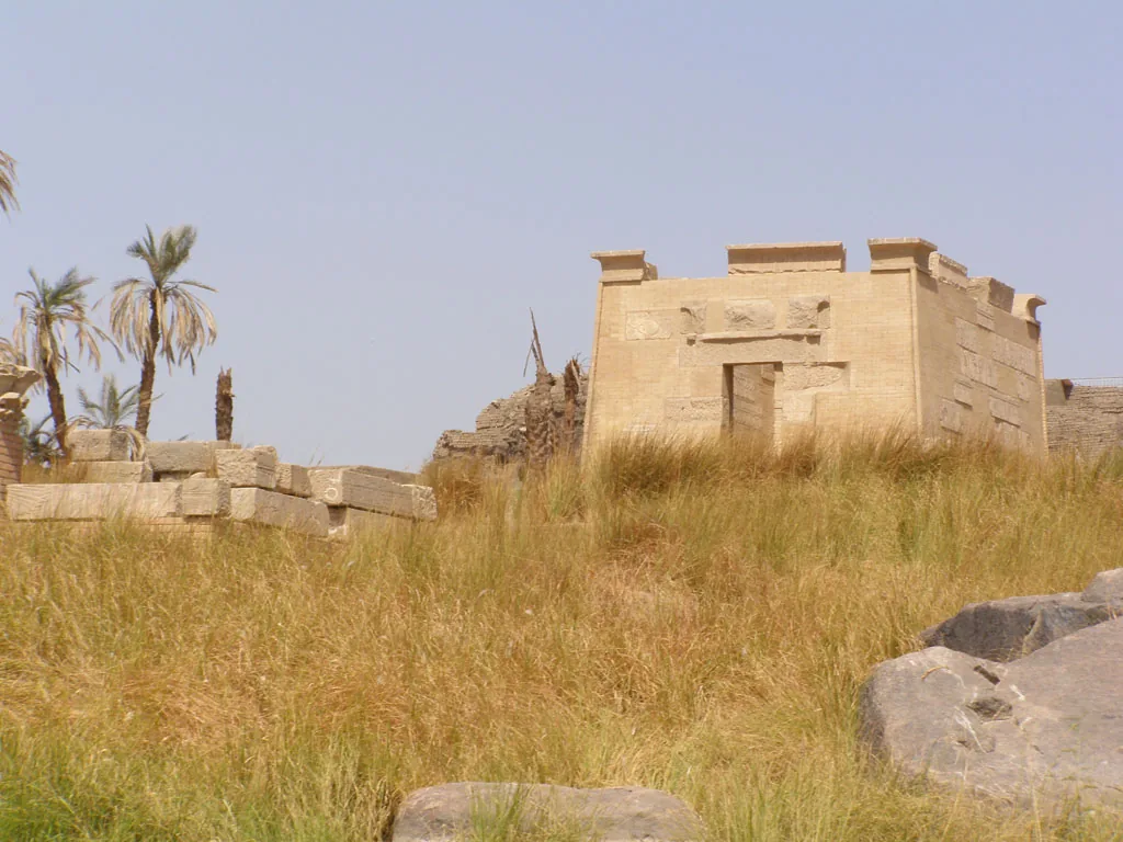 Restored temple remains among grass and granite boulders on Elephantine island.